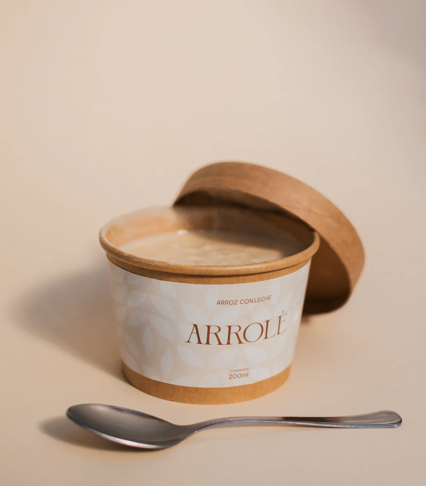Pote de Arrolé cerrado sobre una tabla de madera, con anís estrellado, granos de arroz y canela